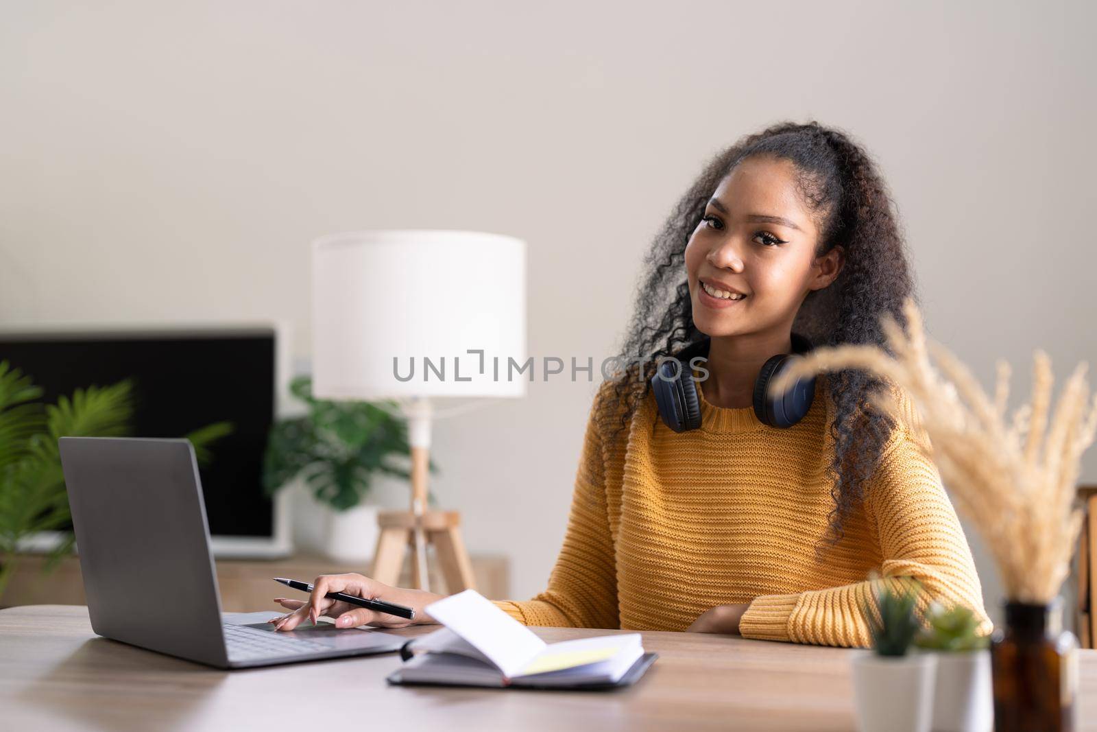 Young woman using laptop computer at office. Student girl working at home. Work or study from home, freelance, business, lifestyle concept.