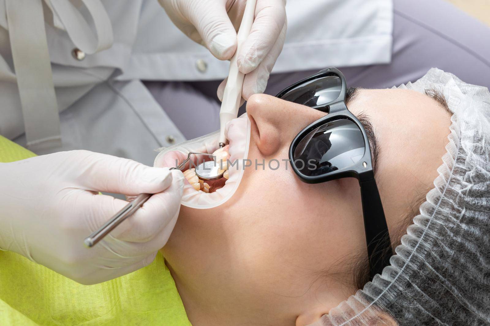 Dentist Examining Patient's Mouth with dental mirror In Clinic. Checkup concept