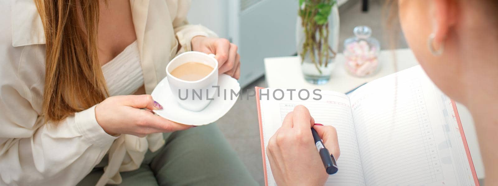 The young caucasian woman has a coffee and appointment with a female doctor in hospital office. by okskukuruza