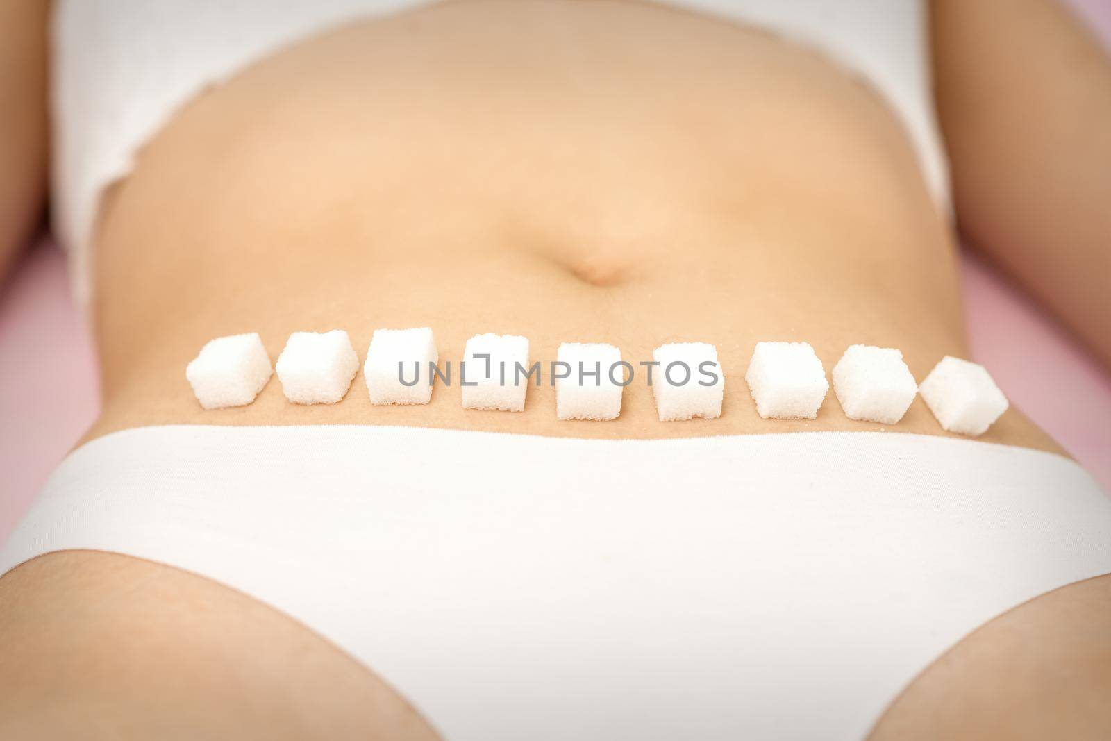 Sugar cubes lying in a row on female bikini zone, the concept of intimate depilation, problems of intimate hygiene. by okskukuruza