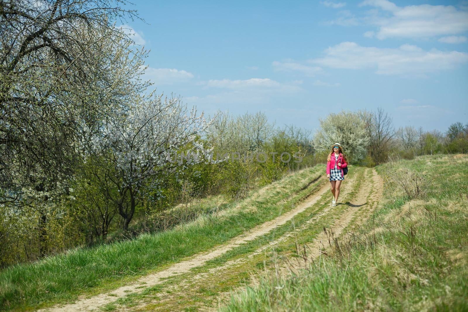 beautiful girl in a dress walking in the spring forest where the trees bloom