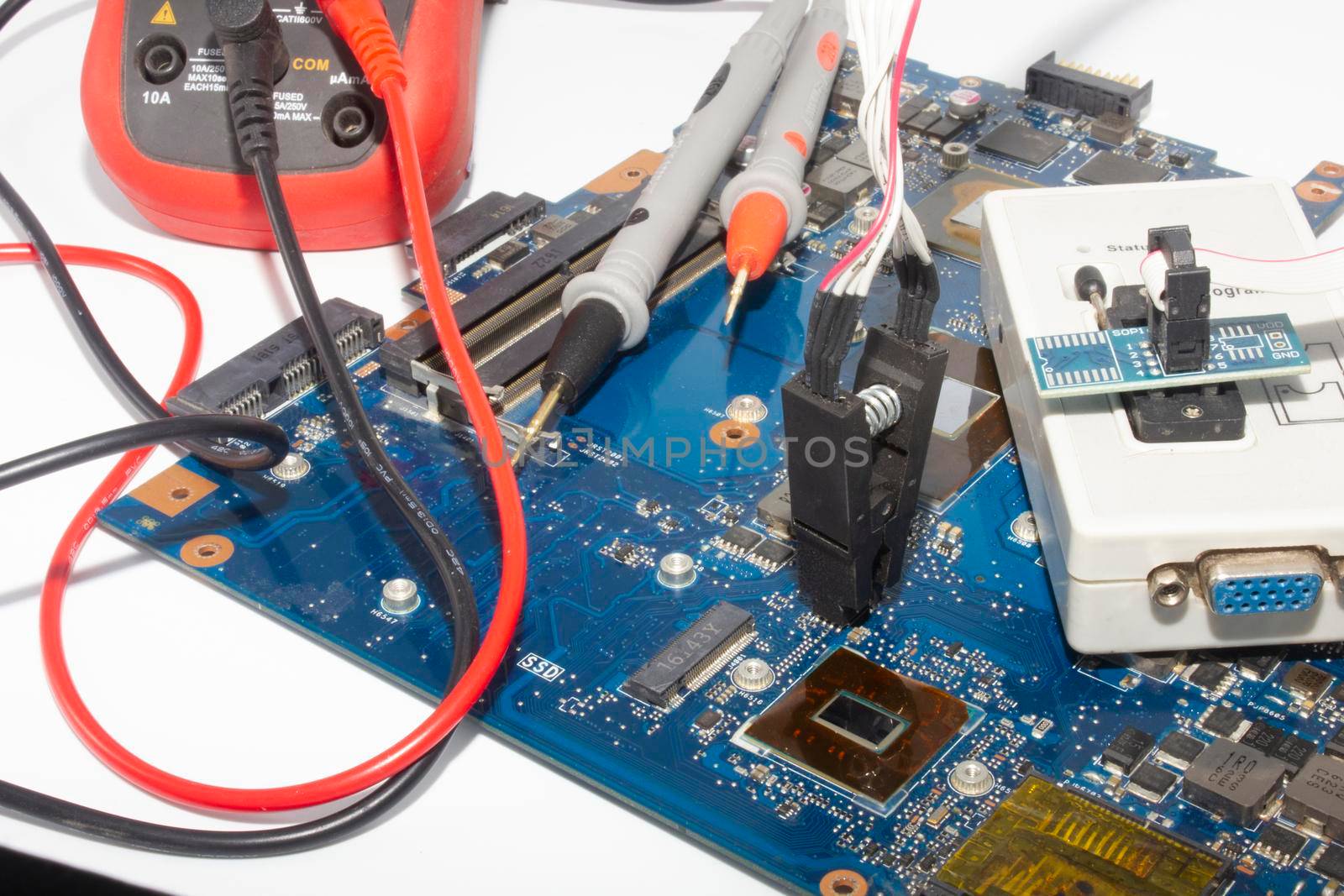 Computer repair service. Engineer repairing laptop mainboard. Hardware developer measure electronic components.