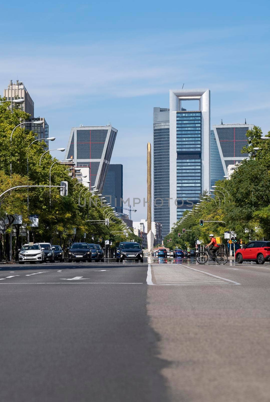 View of Madrid city road with skyscrapers in the background. It is the main avenue in the city full of traffic.