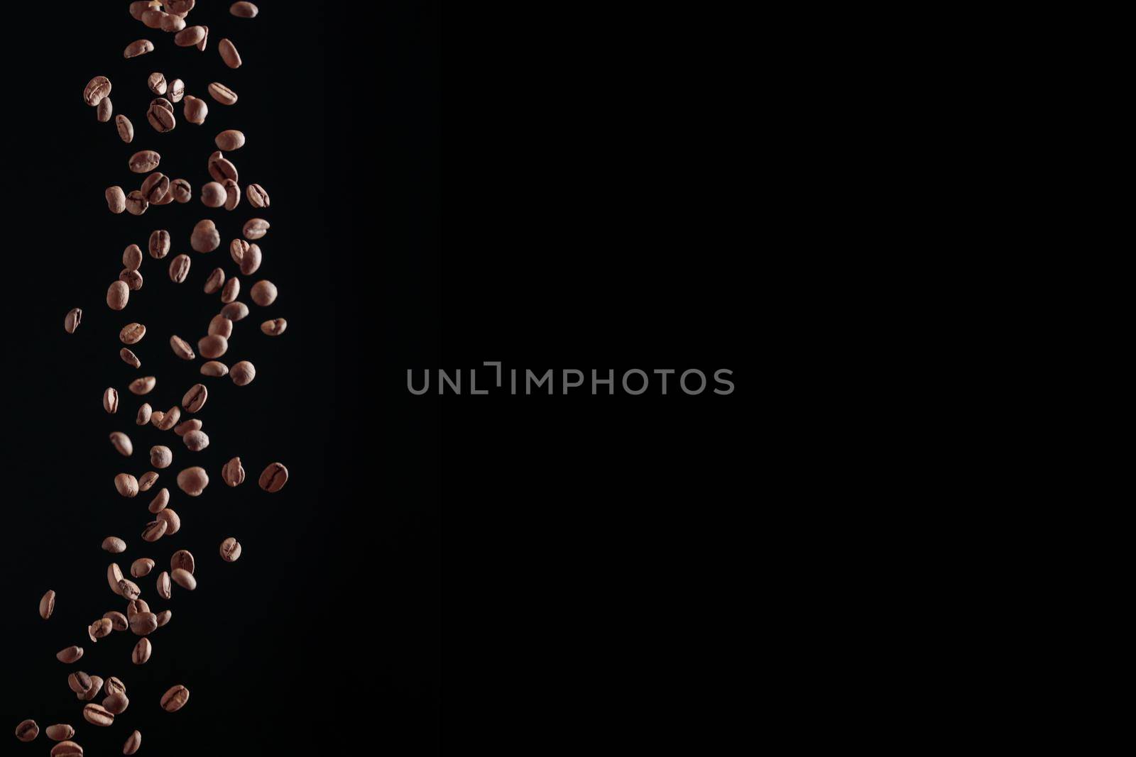 Fresh ccoffee beans in flight on a dark background