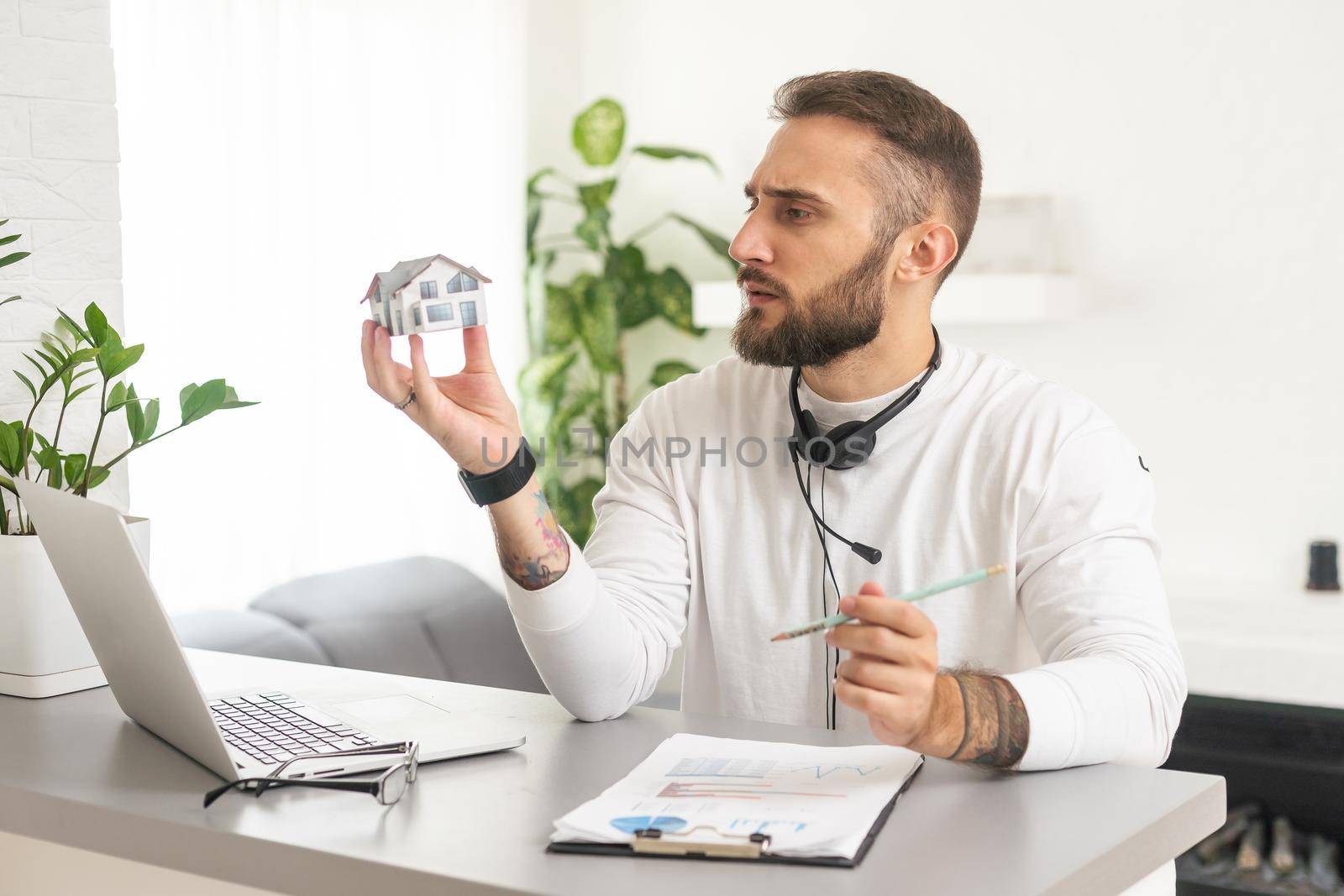 Real Estate House Model Near Laptop On Desk.