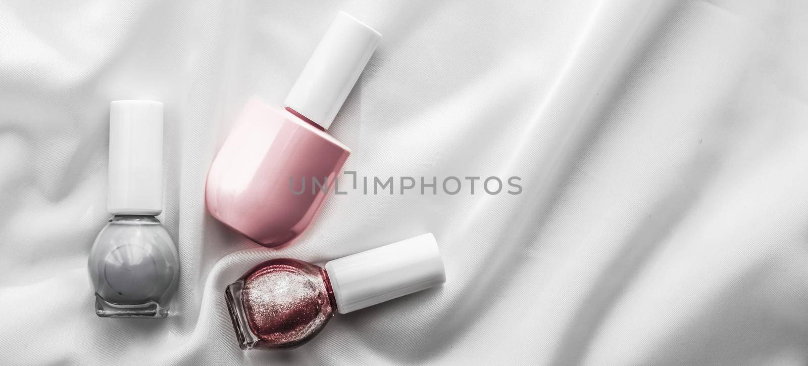 Nail polish bottles on silk background, french manicure products and nailpolish make-up cosmetics for luxury beauty brand and holiday flatlay art design by Anneleven