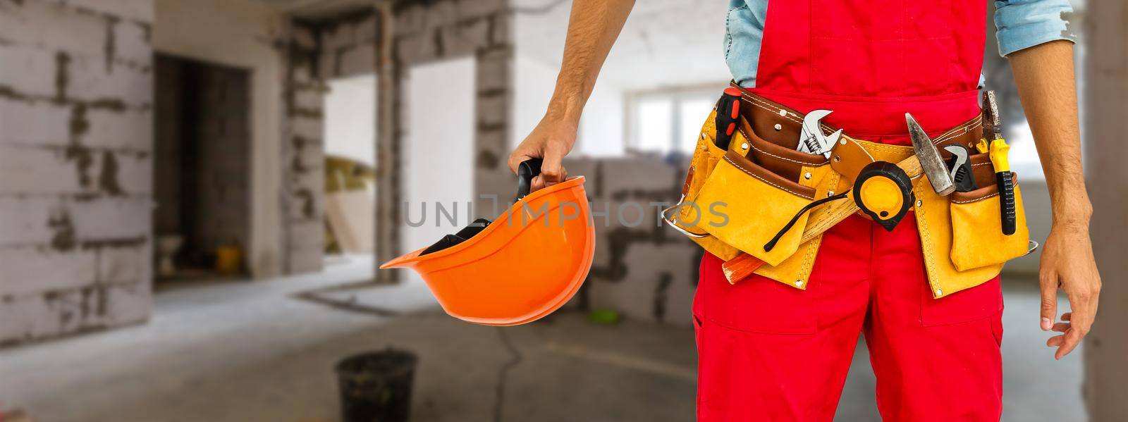 Portrait of cheerful young worker wearing hardhat over white background.