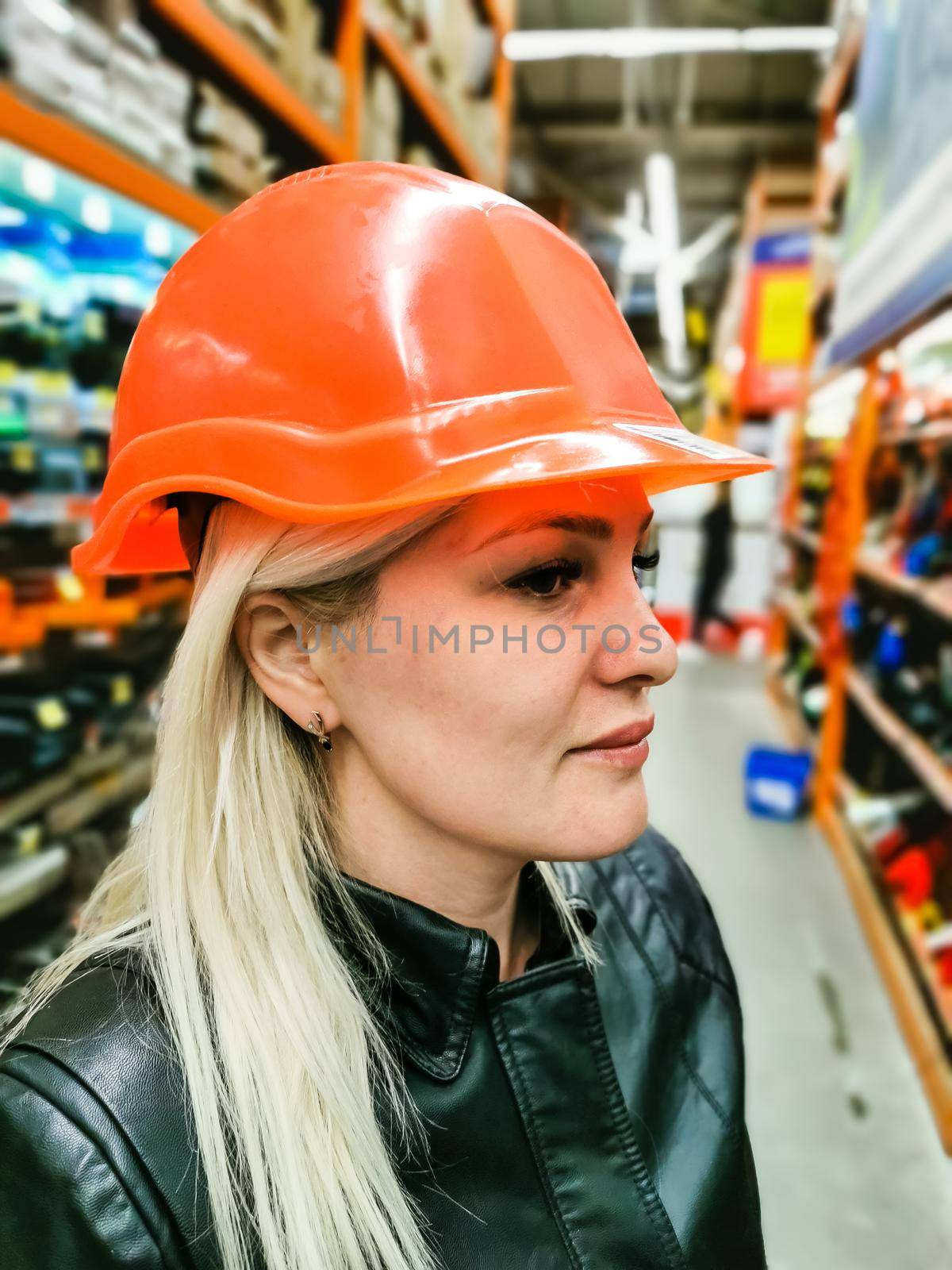 a woman measures a helmet in a store.
