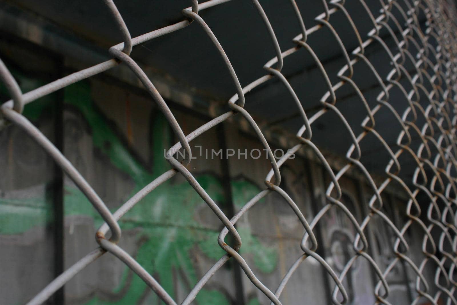 Rusty metal mesh close-up on the background of painted walls.