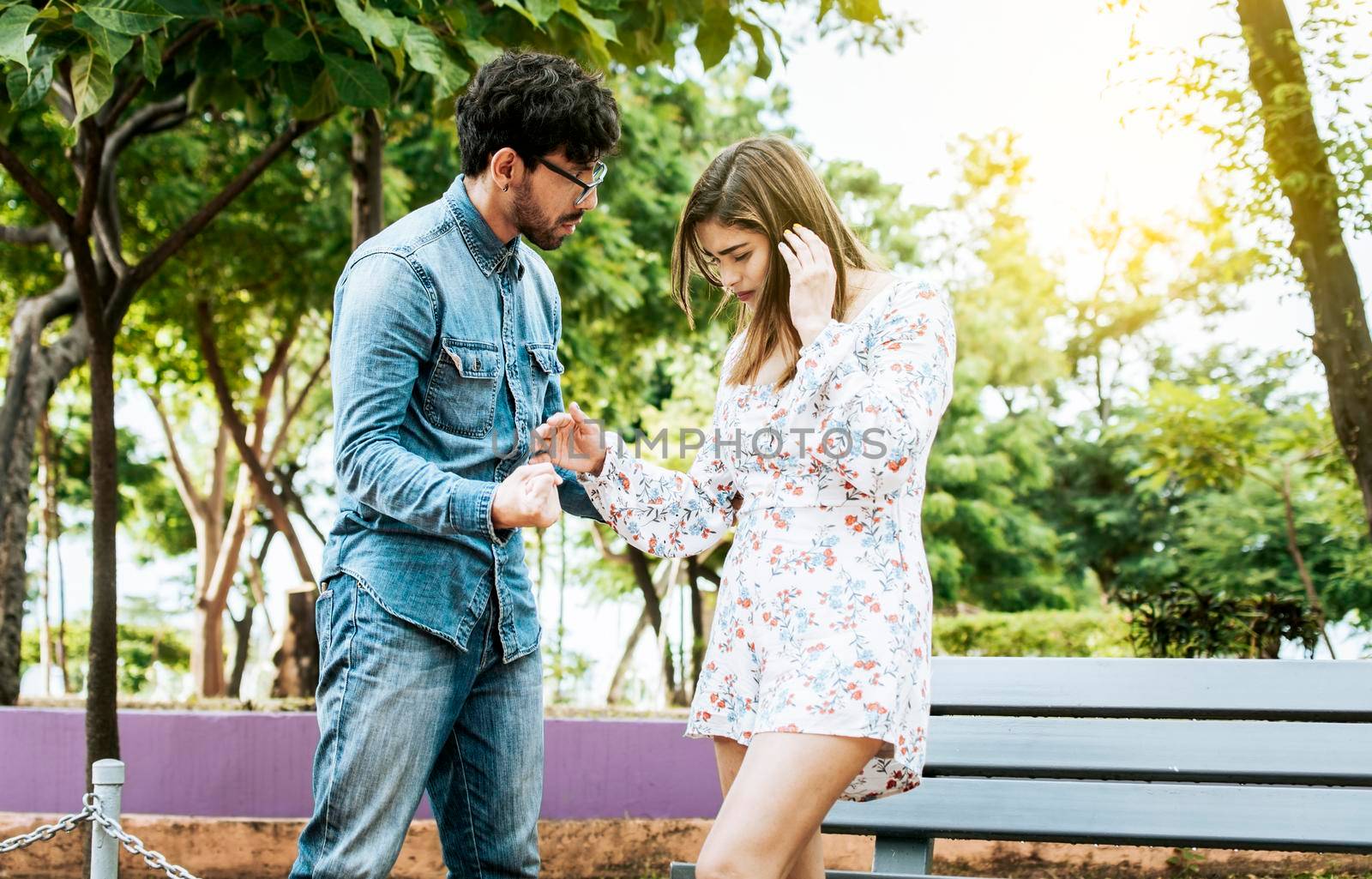 Young couple arguing misunderstanding in a park, Unhappy couple standing arguing in a park. Disgusted teenage couple arguing in a park, Man and woman arguing in a park by isaiphoto