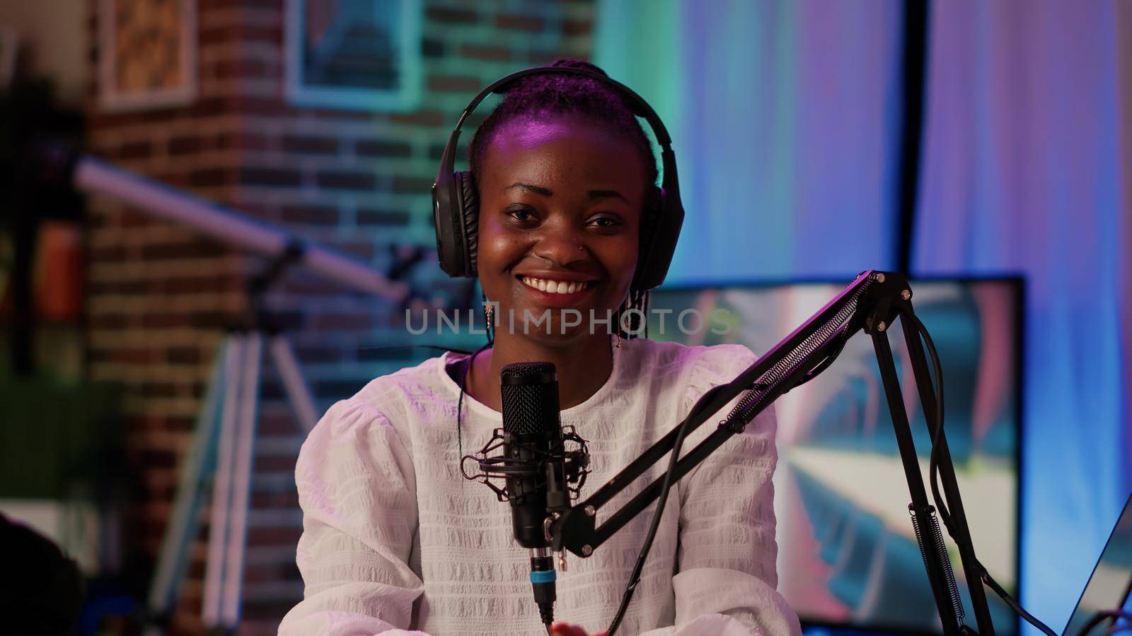 Portrait of online radio host smiling confident at camera while broadcasting live using professional equipment by DCStudio