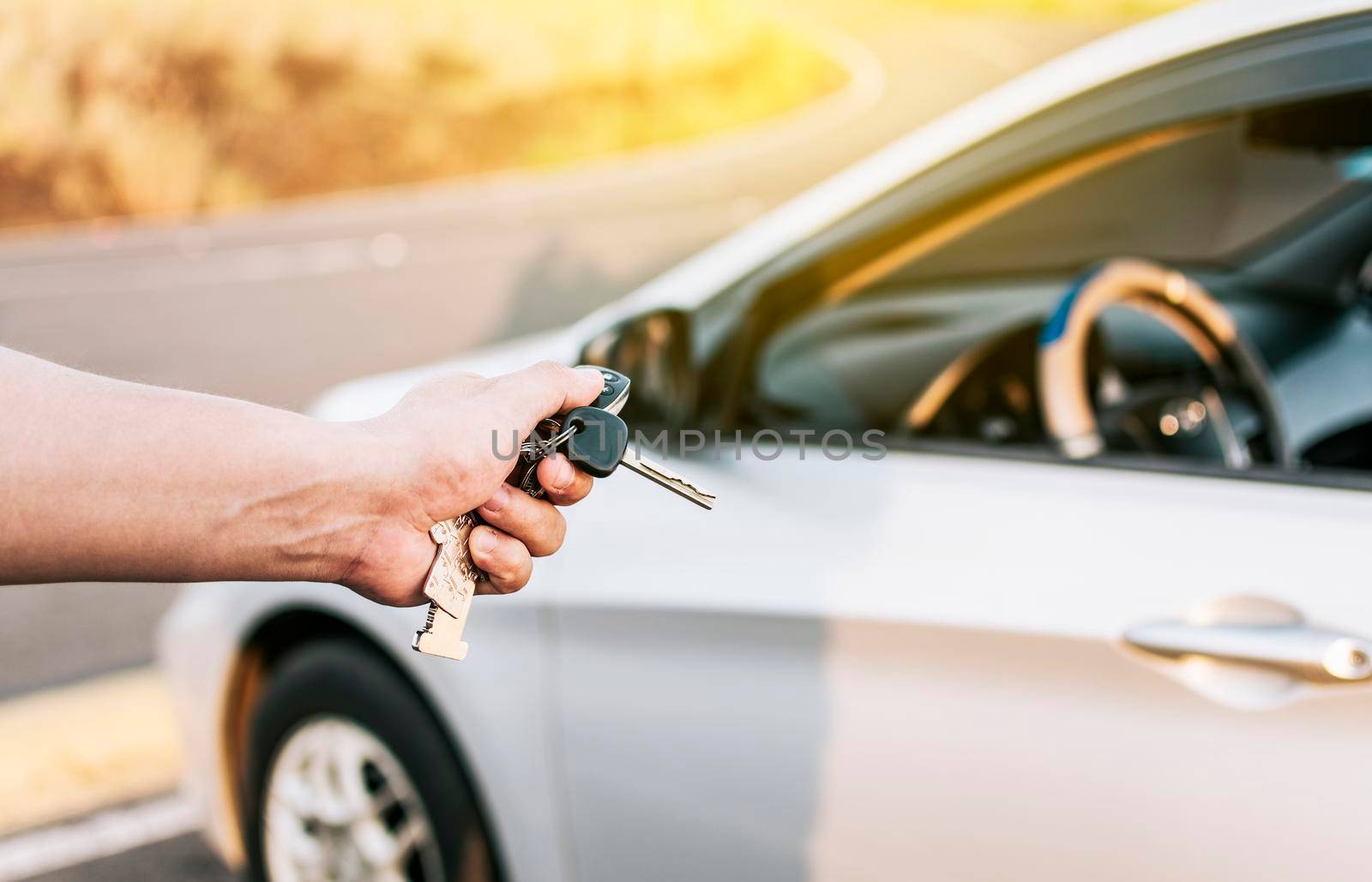 Driver hands showing the keys outside the vehicle, Vehicle rental concept. Close-up of driver outside car holding keys. Driver hands showing the car keys