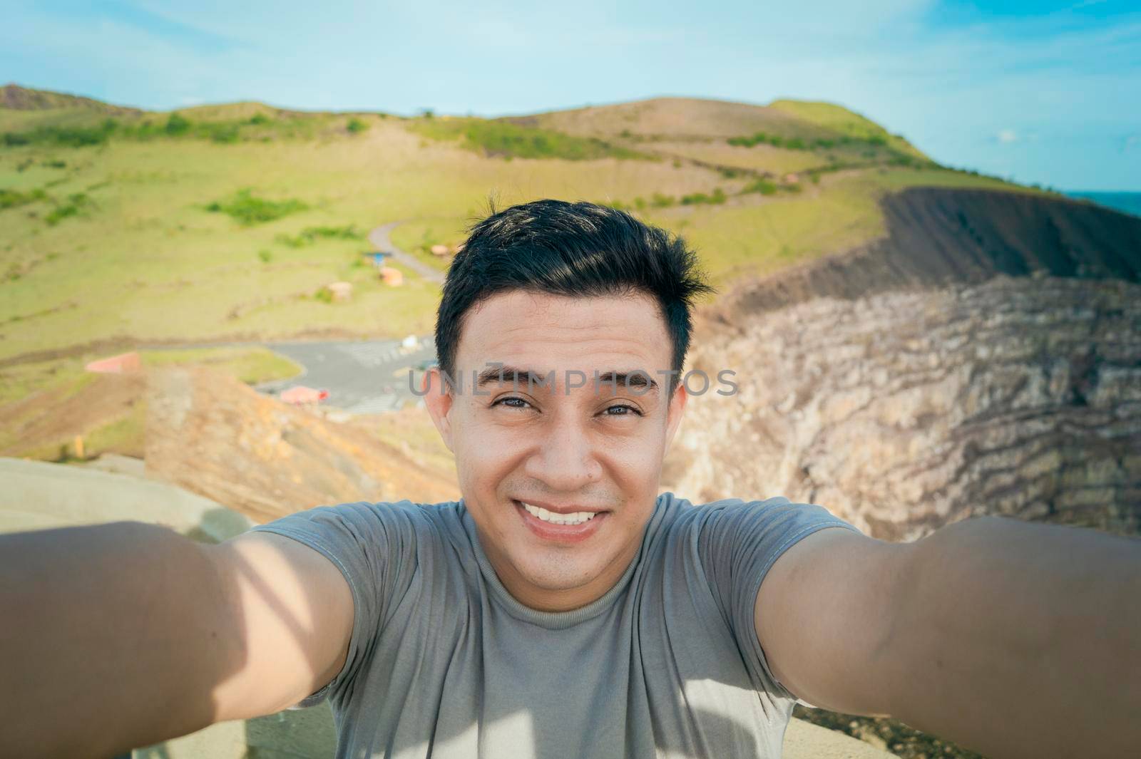 Adventurous man taking a selfie at a viewpoint. Close up of person taking an adventure selfie, Tourist taking a selfie at a viewpoint. Handsome tourist taking a selfie on vacation by isaiphoto