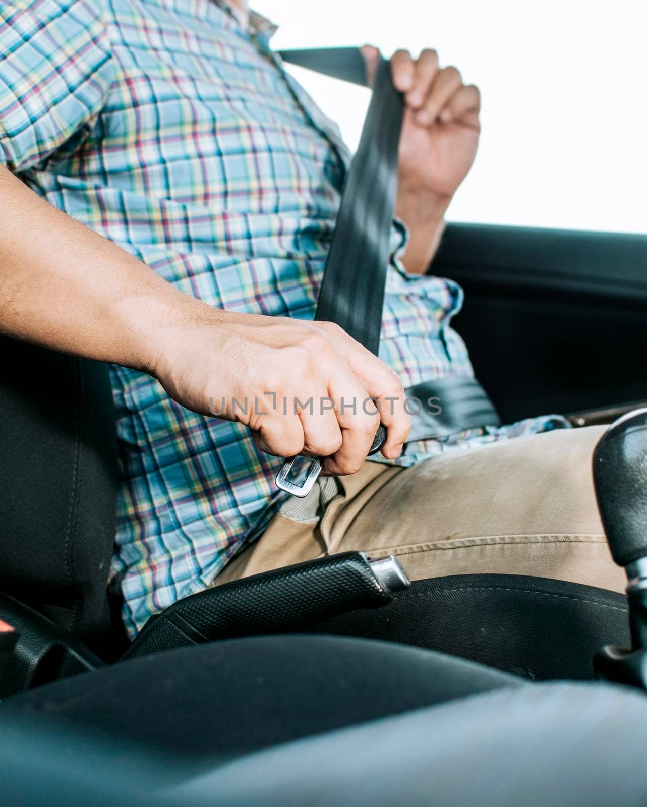 Driver hands fastening the seat belt, Close up of person hands putting on the seat belt. Driver's hands putting on the seat belt. Safety belt for accident prevention by isaiphoto