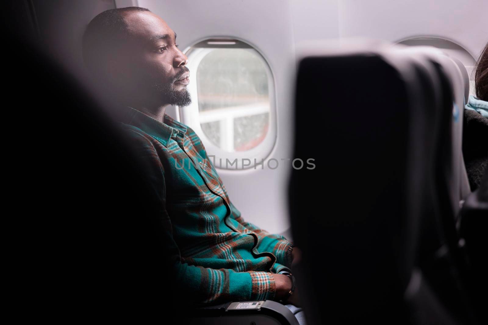 African american tourist flying in economy class with airplane to leave on business work trip. Freelancer travelling abroad with international airways, using plane transportation.