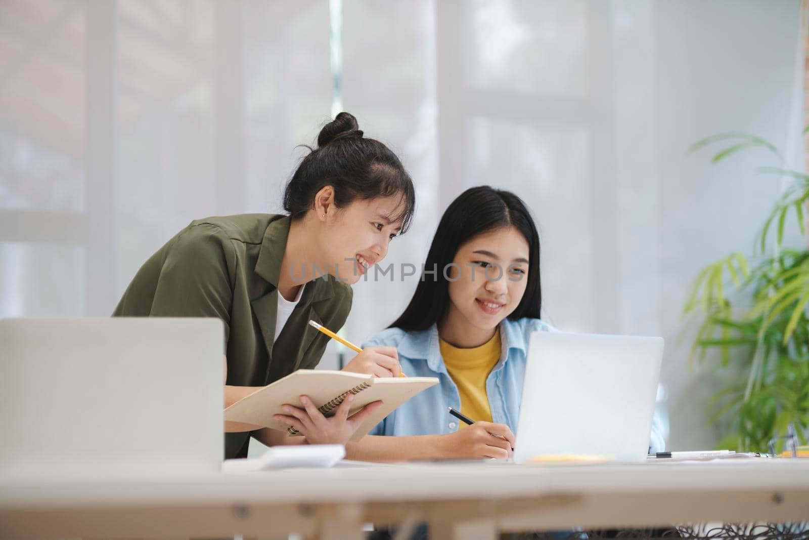 Young asian university students studying learning discuss working on computer, concept educational. Startup Business teamwork meeting to discuss. concept business teamwork.