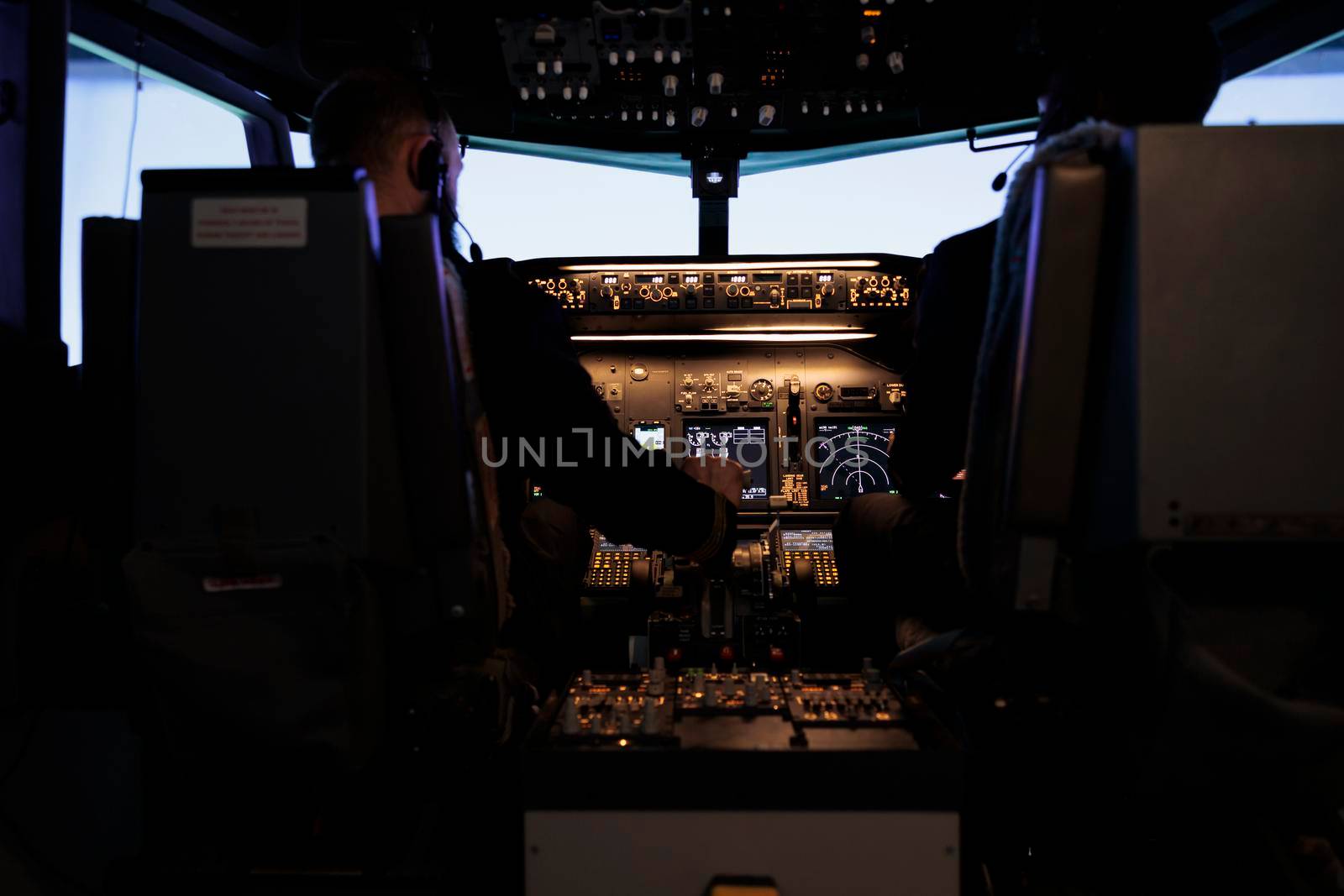 Diverse team of captain and pilot pushing engine throttle lever to takeoff with airplane from aviation cockpit. Aircrew men flying plane jet using dashboard and control panel command.