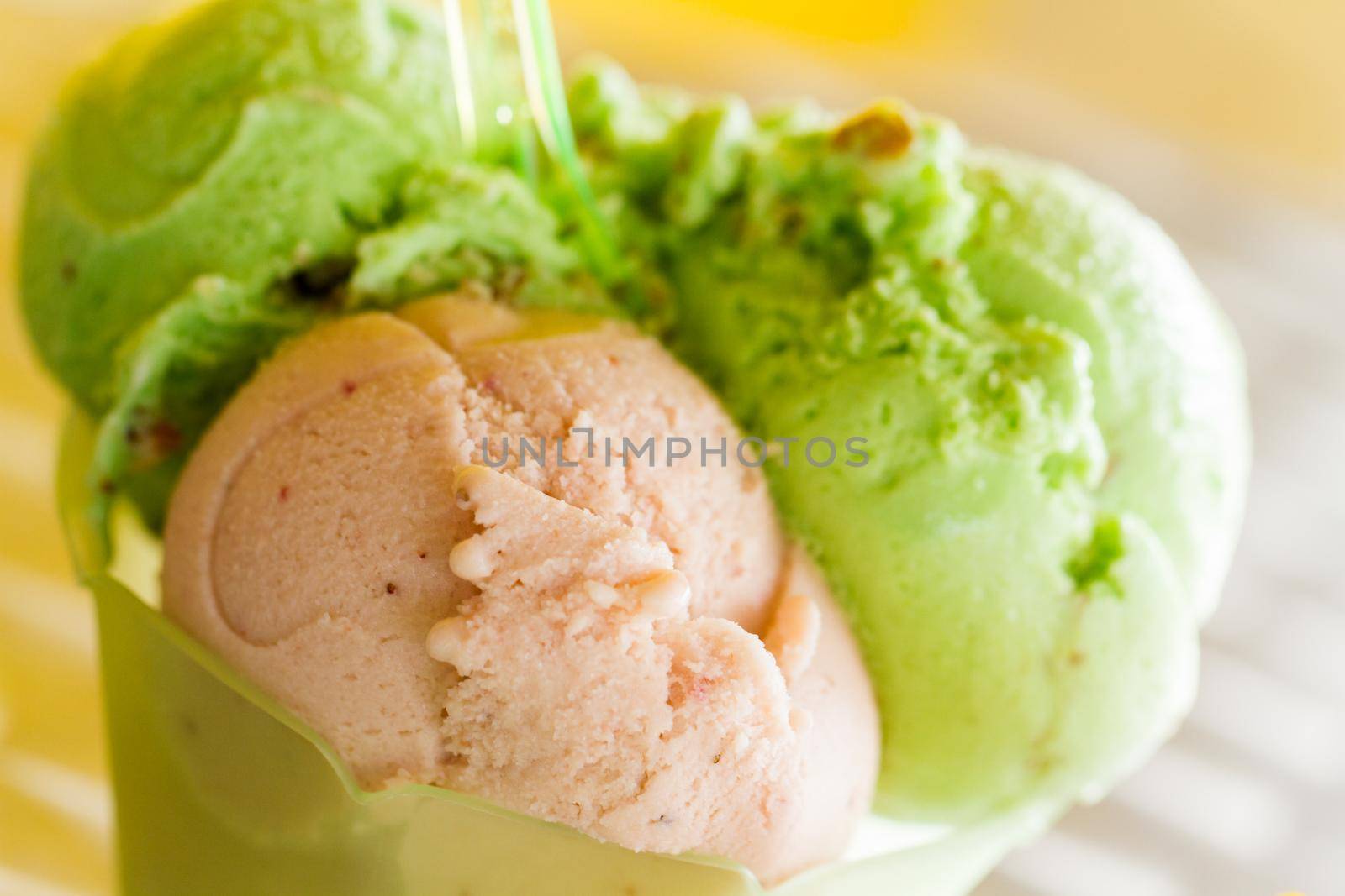 Green gelato in green plastic cup.