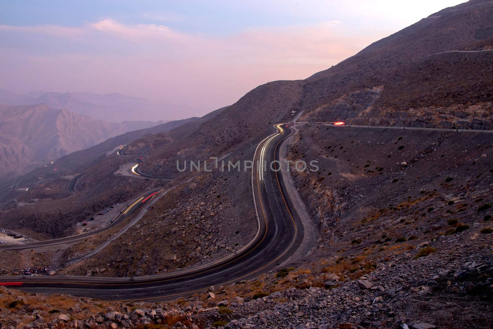View from Jebael Jais mountain of Ras Al Khaimah emirate in the evening. United Arab Emirates, Outdoors. Light trails from the car