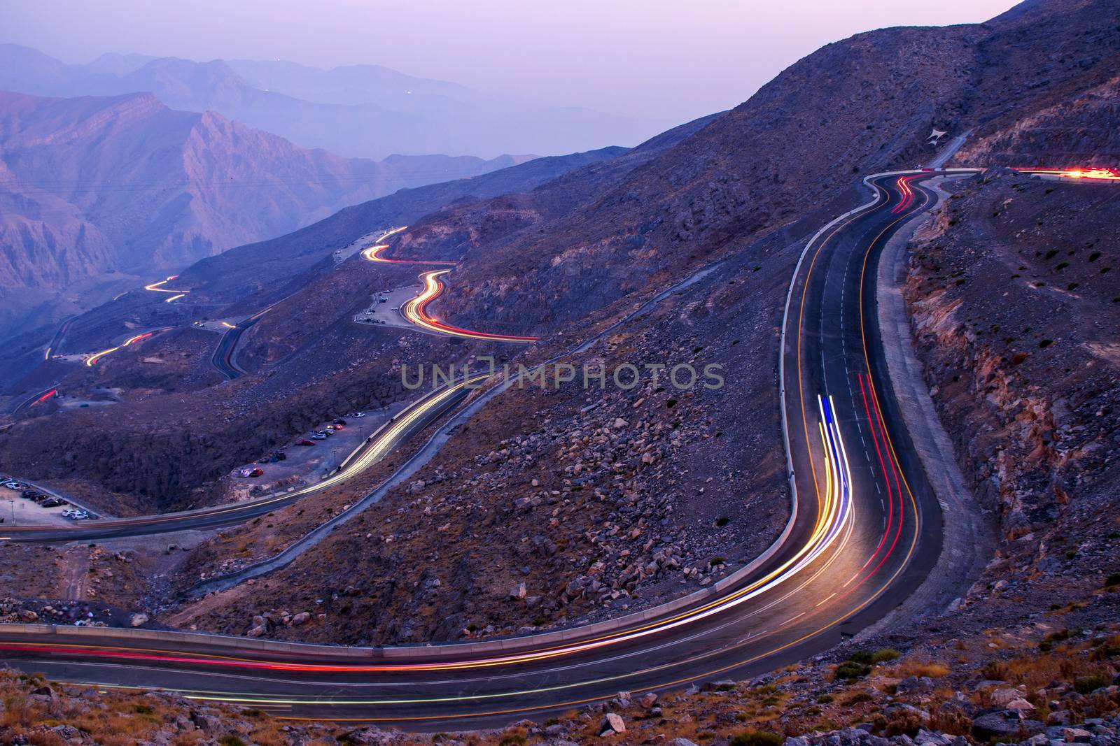 View from Jebael Jais mountain of Ras Al Khaimah emirate in the evening. United Arab Emirates, Outdoors. Light trails from the car