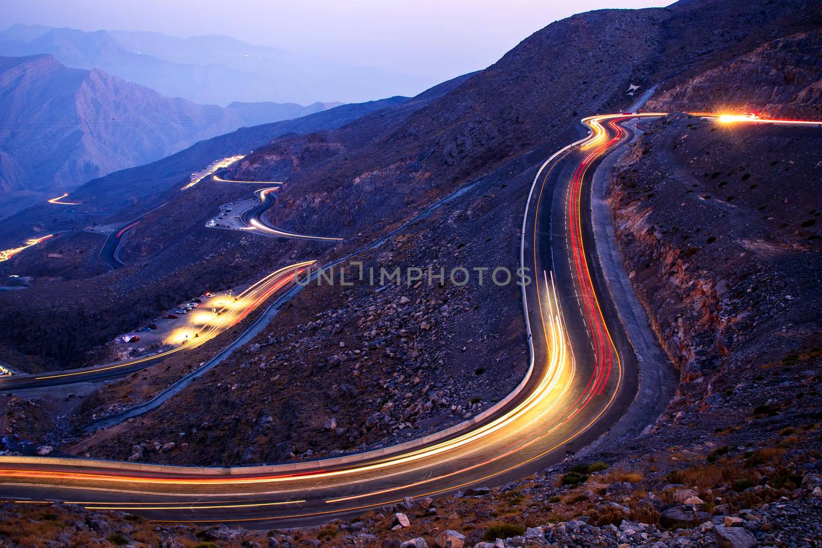 View from Jebael Jais mountain of Ras Al Khaimah emirate in the evening. United Arab Emirates, Outdoors. Light trails from the car