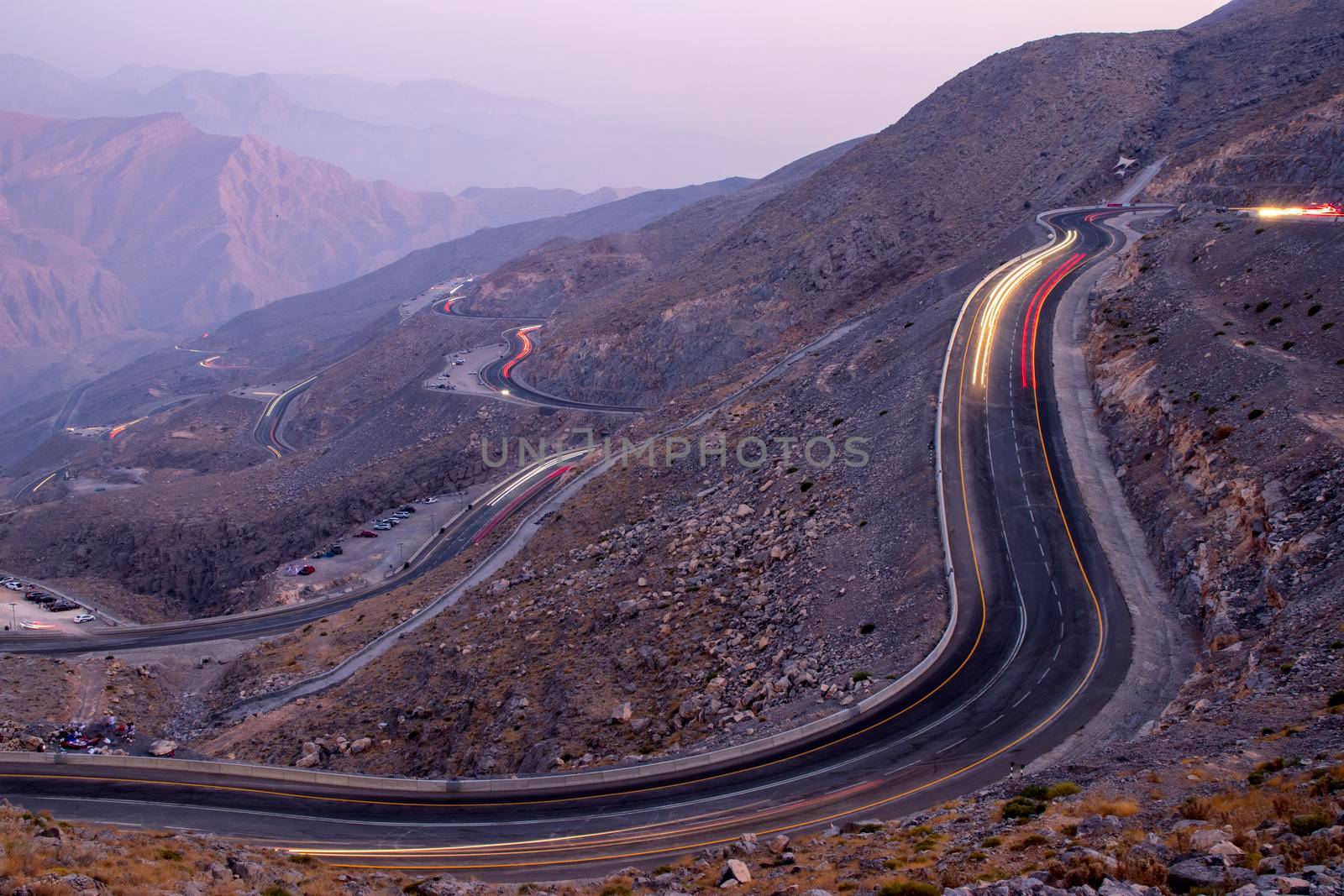 View from Jebael Jais mountain of Ras Al Khaimah emirate in the evening. United Arab Emirates, Outdoors. Light trails from the car