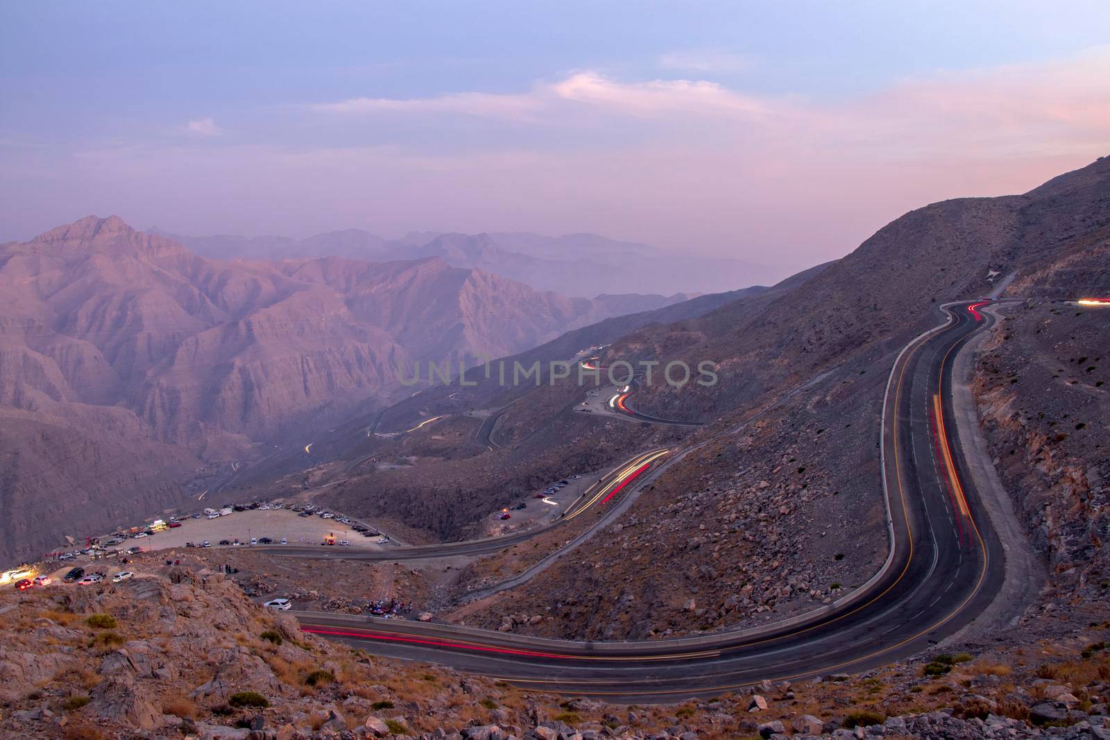 View from Jebael Jais mountain of Ras Al Khaimah emirate in the evening. United Arab Emirates, Outdoors. Light trails from the car