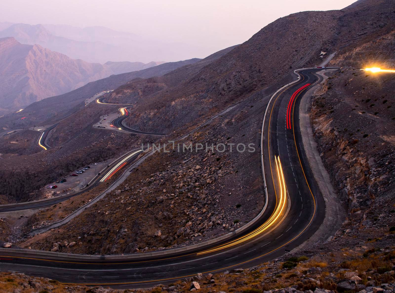 View from Jebael Jais mountain of Ras Al Khaimah emirate in the evening. United Arab Emirates, Outdoors. Light trails from the car