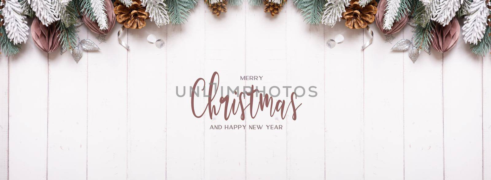 Merry Christmas and Happy New Year text greeting banner with flat lay composition from pine, cones, balls on wooden background.