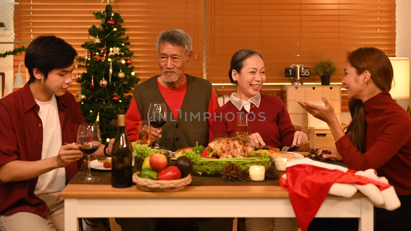 Group of people enjoying Thanksgiving meal in comfortable home. Celebration, holidays and Christmas concept by prathanchorruangsak