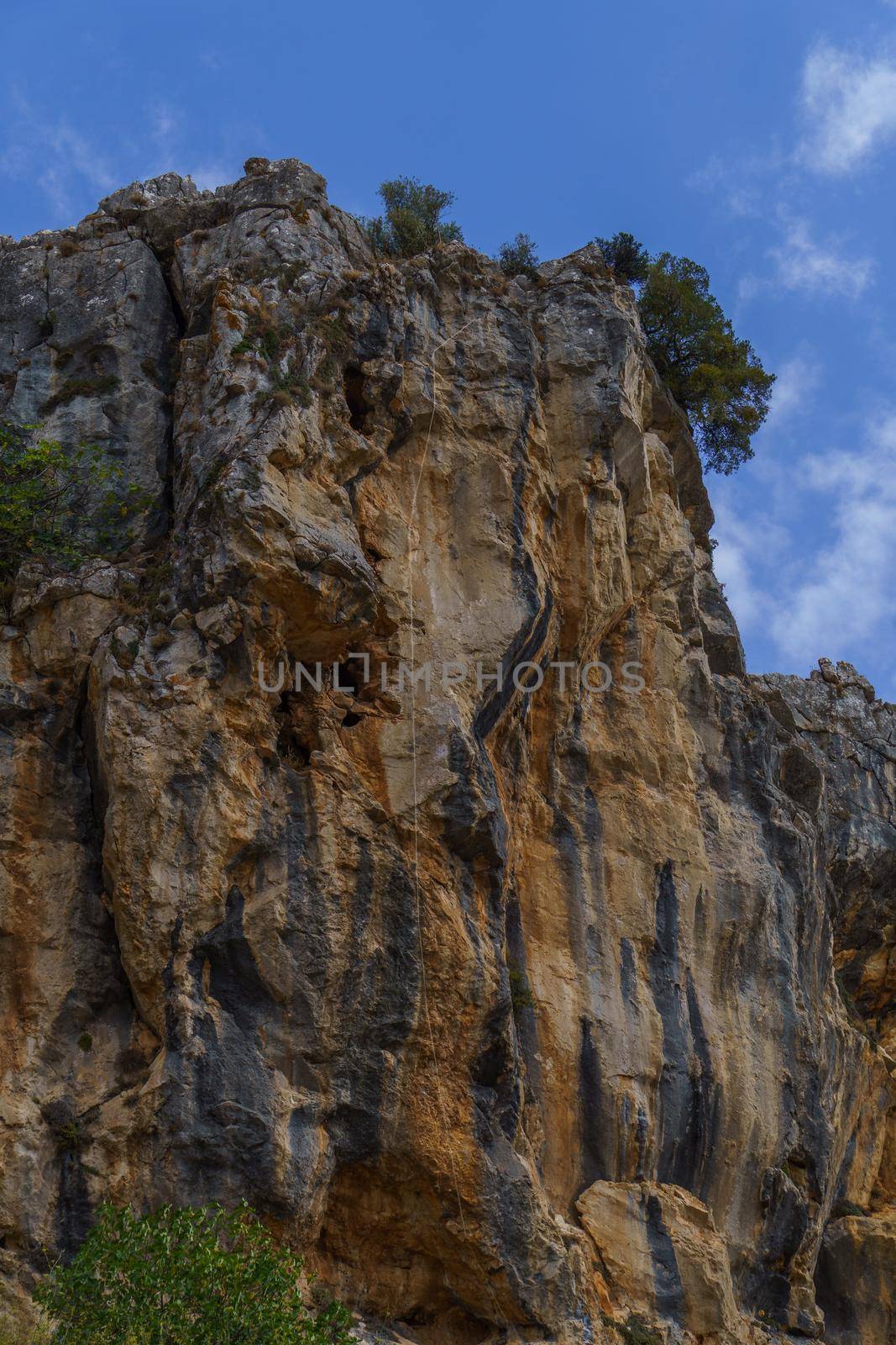 majestic granite mountain with safety rope for climbing blue sky with clouds in the background