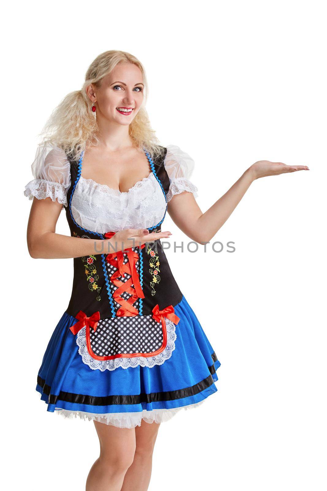 Beautiful young blond girl in dirndl drinks out of oktoberfest beer stein. Isolated on white background. pointing finger and smiling. copyspace desing concept