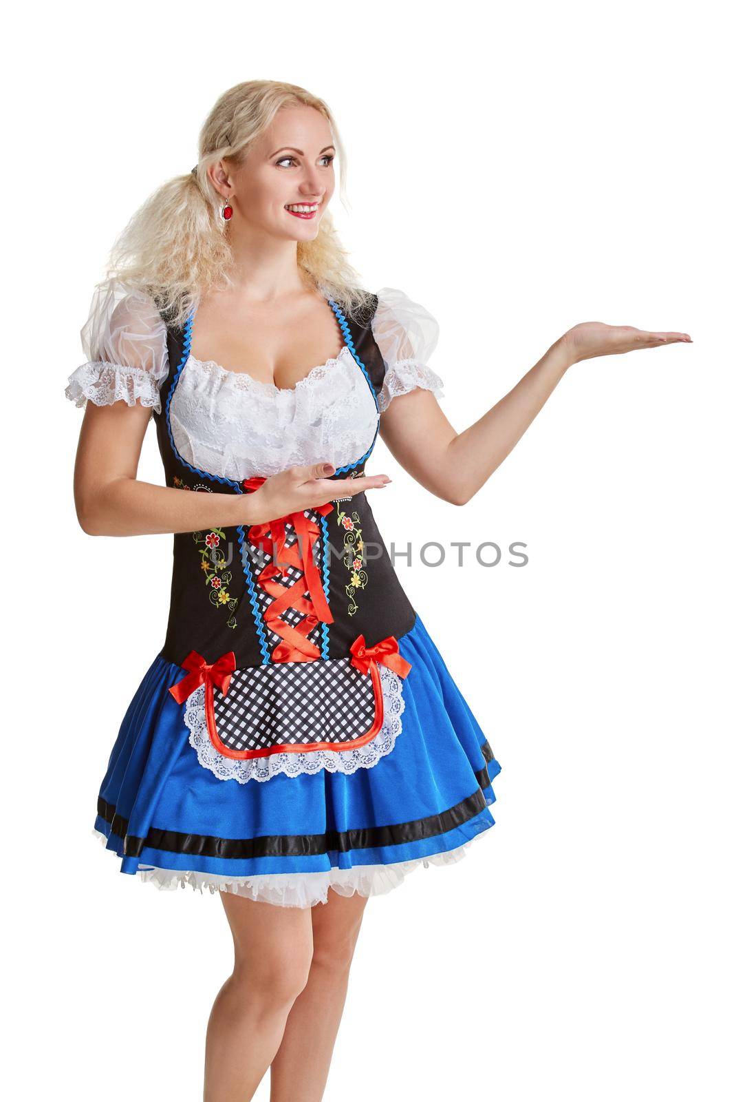 Beautiful young blond girl in dirndl drinks out of oktoberfest beer stein. Isolated on white background. pointing finger and smiling. copyspace desing concept