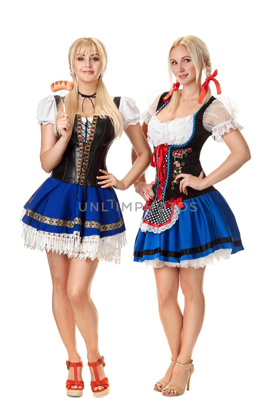 Full length portrait of a two blond womans with traditional costume holding beer glasses isolated on white background. by nazarovsergey