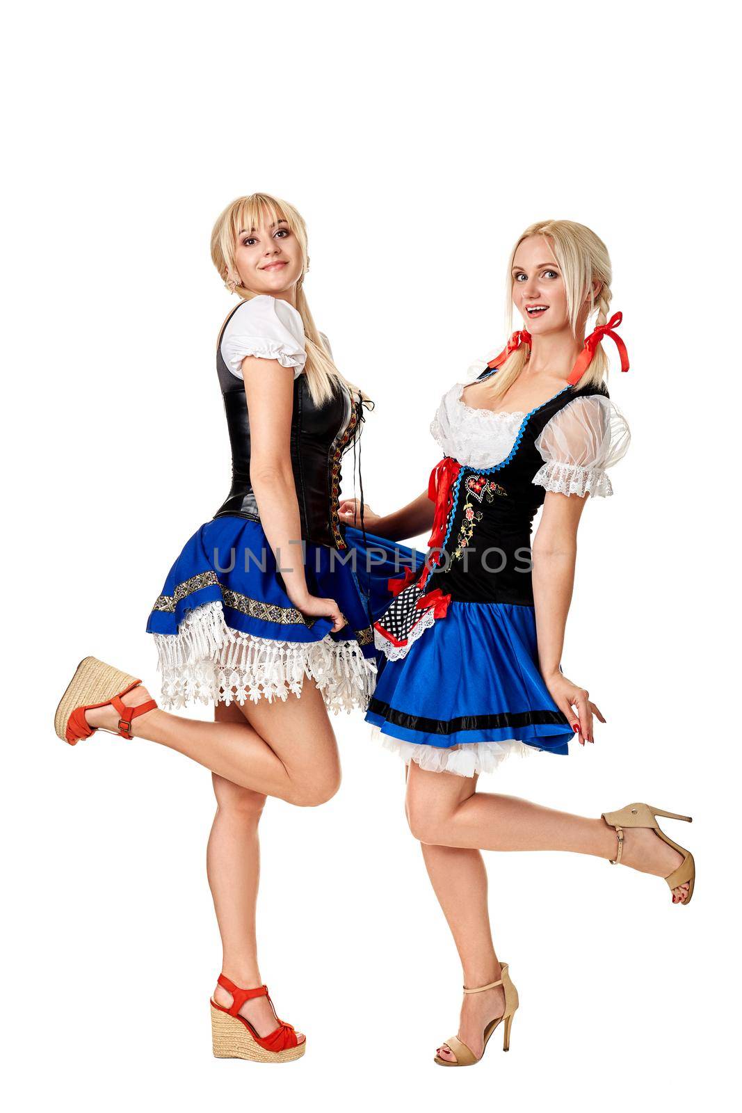 A full length portrait of two beautiful women in a traditional costume isolated on white. Oktoberfest by nazarovsergey