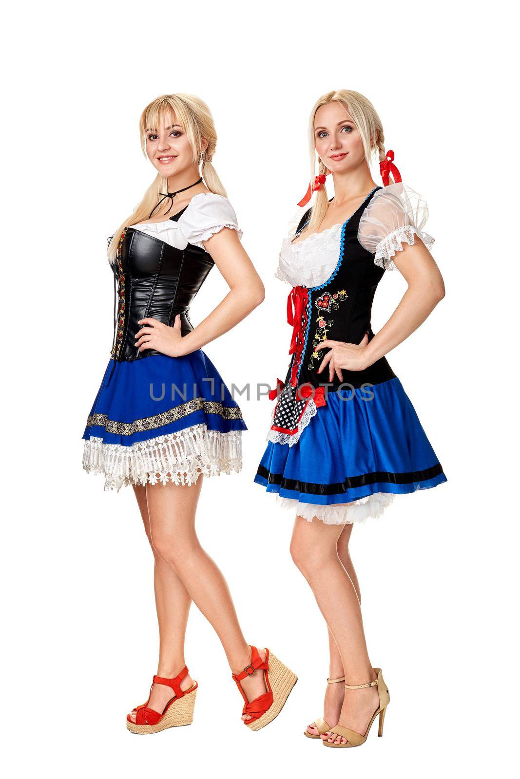 A full length portrait of two beautiful women in a traditional costume isolated on white. Oktoberfest by nazarovsergey