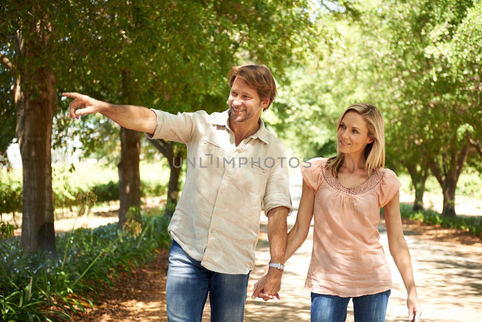 Enjoying the beauty that nature has to offer. a mature couple enjoying a walk in the park. by YuriArcurs