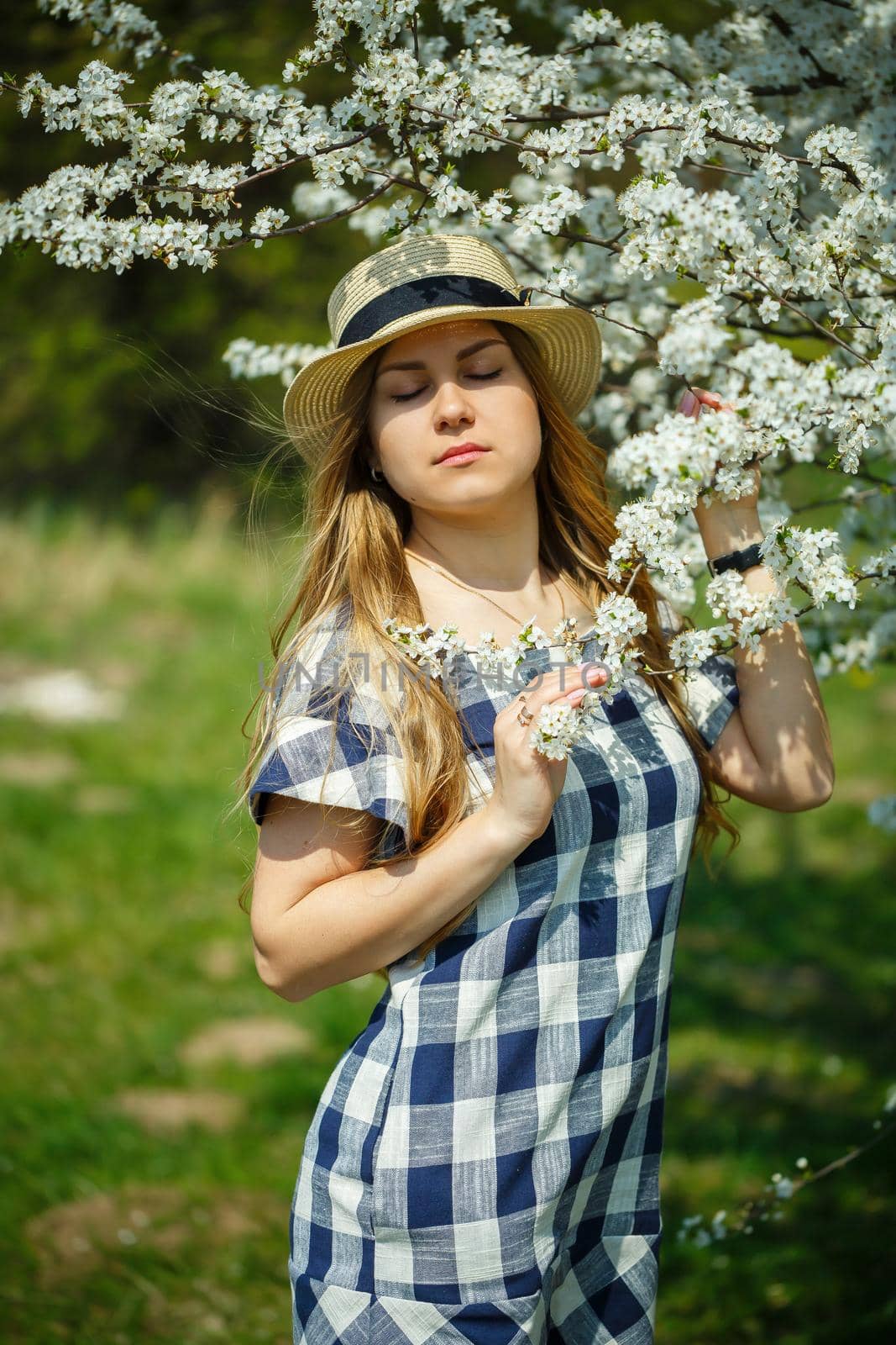 beautiful girl in a dress walking in the spring forest where the trees bloom