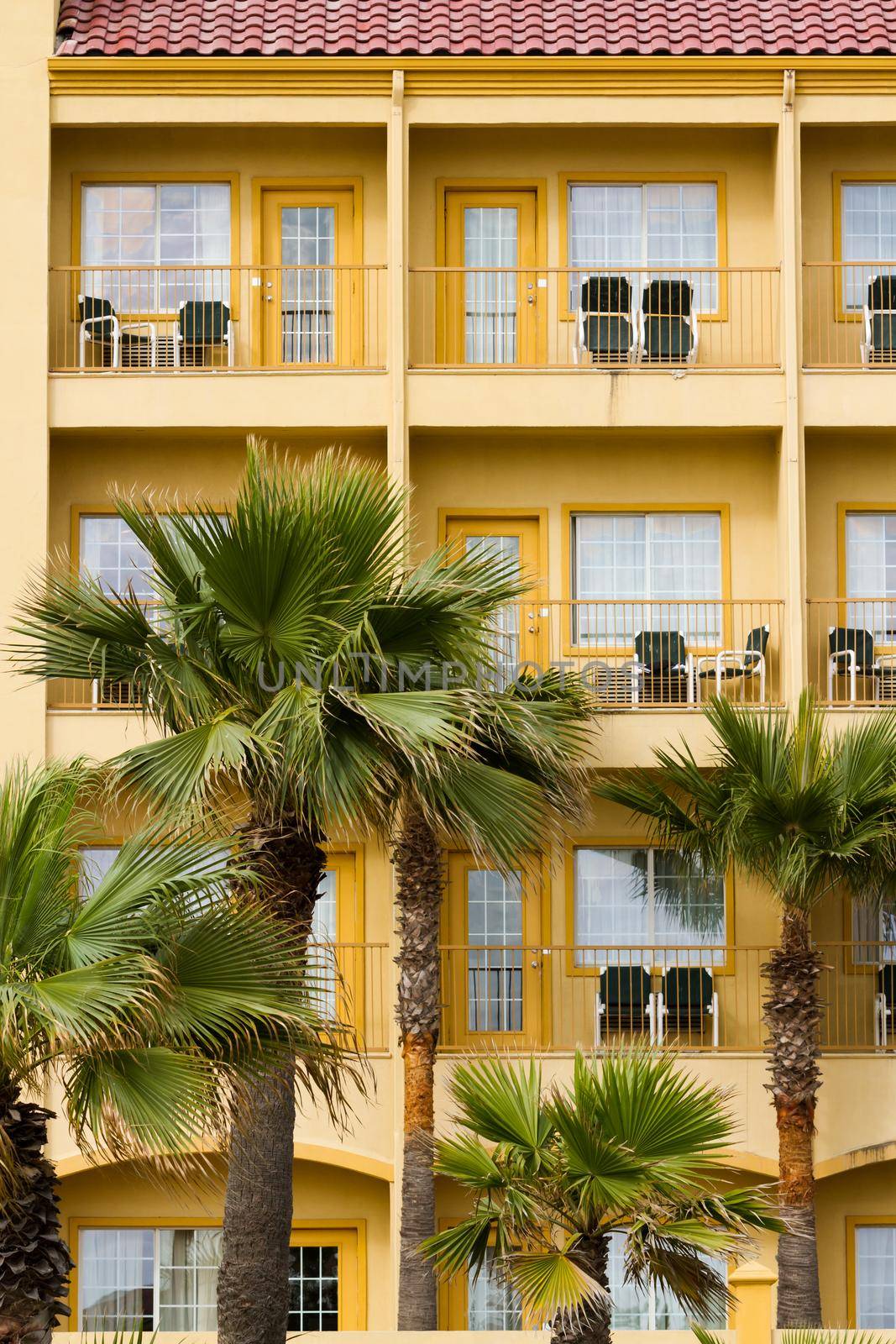 Yellow hotel with balconies.