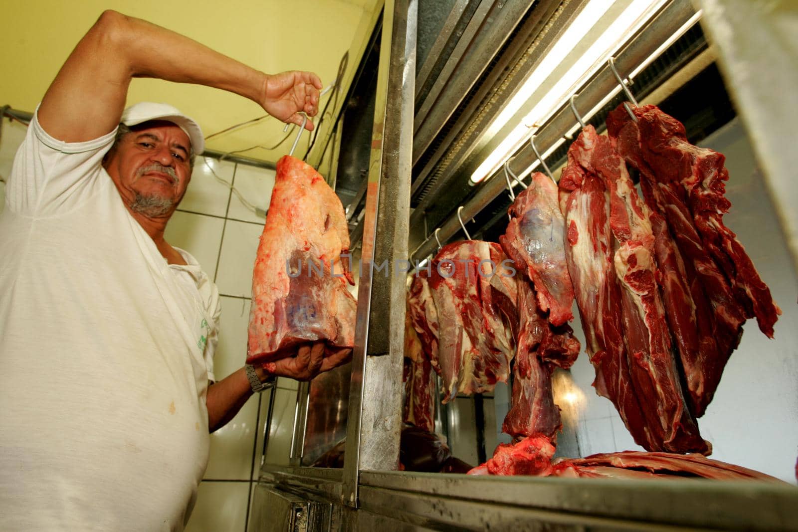 eunapolis, bahia / brazil - october 6, 2009: a butcher is seen holding a piece of bolvina meat on a market in the city of Eunapolis, in southern Bahia.