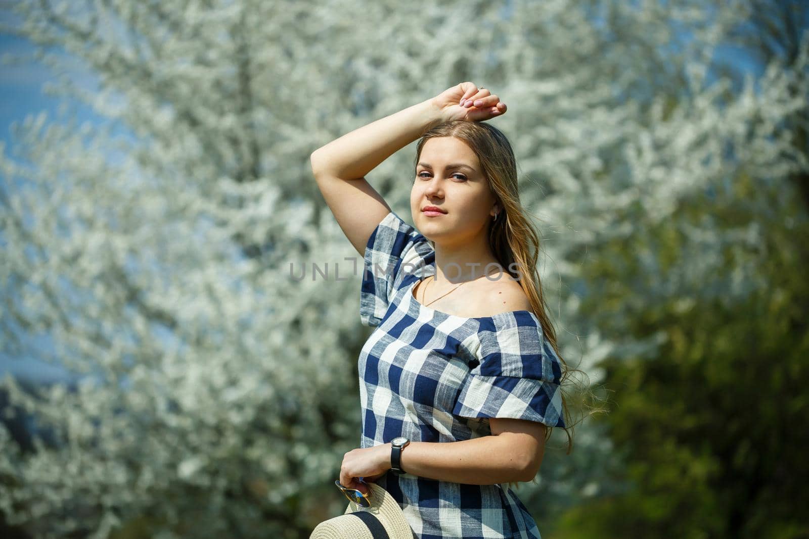 beautiful girl in a dress walking in the spring forest where the trees bloom