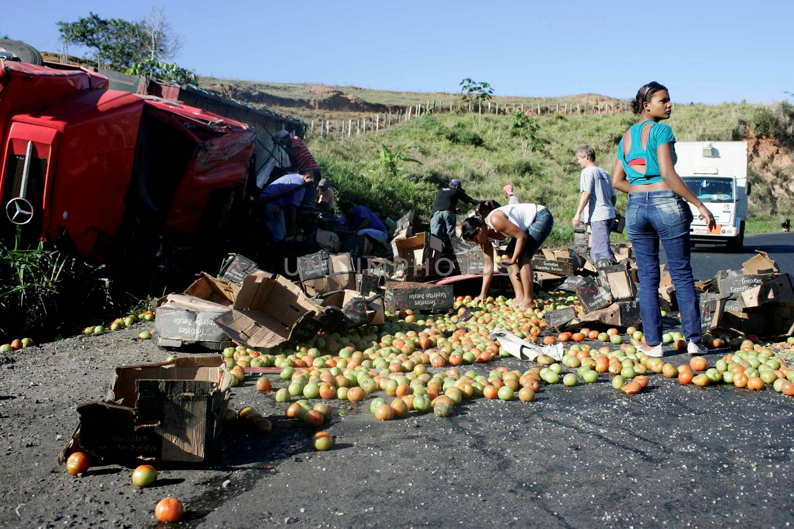 teixeira de freitas, bahia / brazil - july 28, 2009: Truck carrying tomatoes turns over and the cargo is looted by people on the BR 101 highway in Teixeira de Freitas.