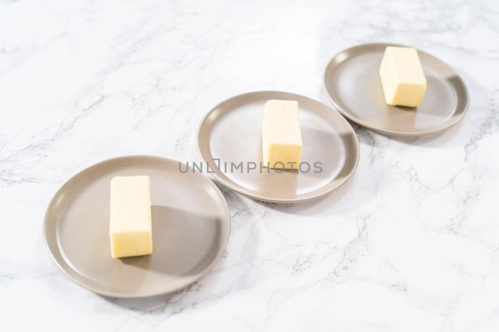Sticks of unsalted butter on the small plates.