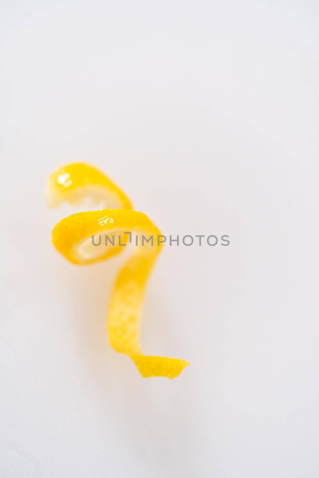 Preparing lemon swirls from the organic lemon to decorate the cocktail.