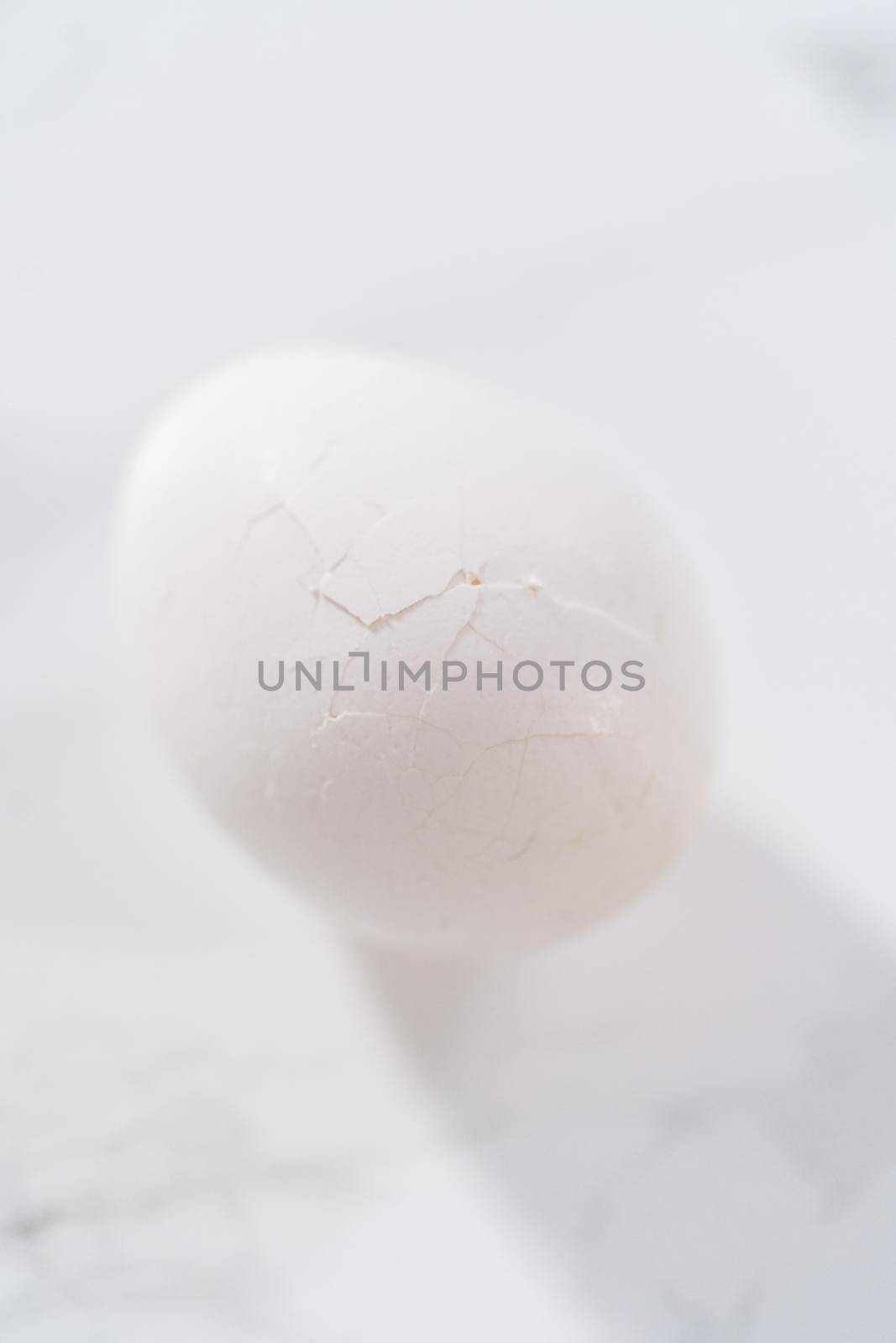 Peeling hard-boiled eggs at the marble kitchen counter.