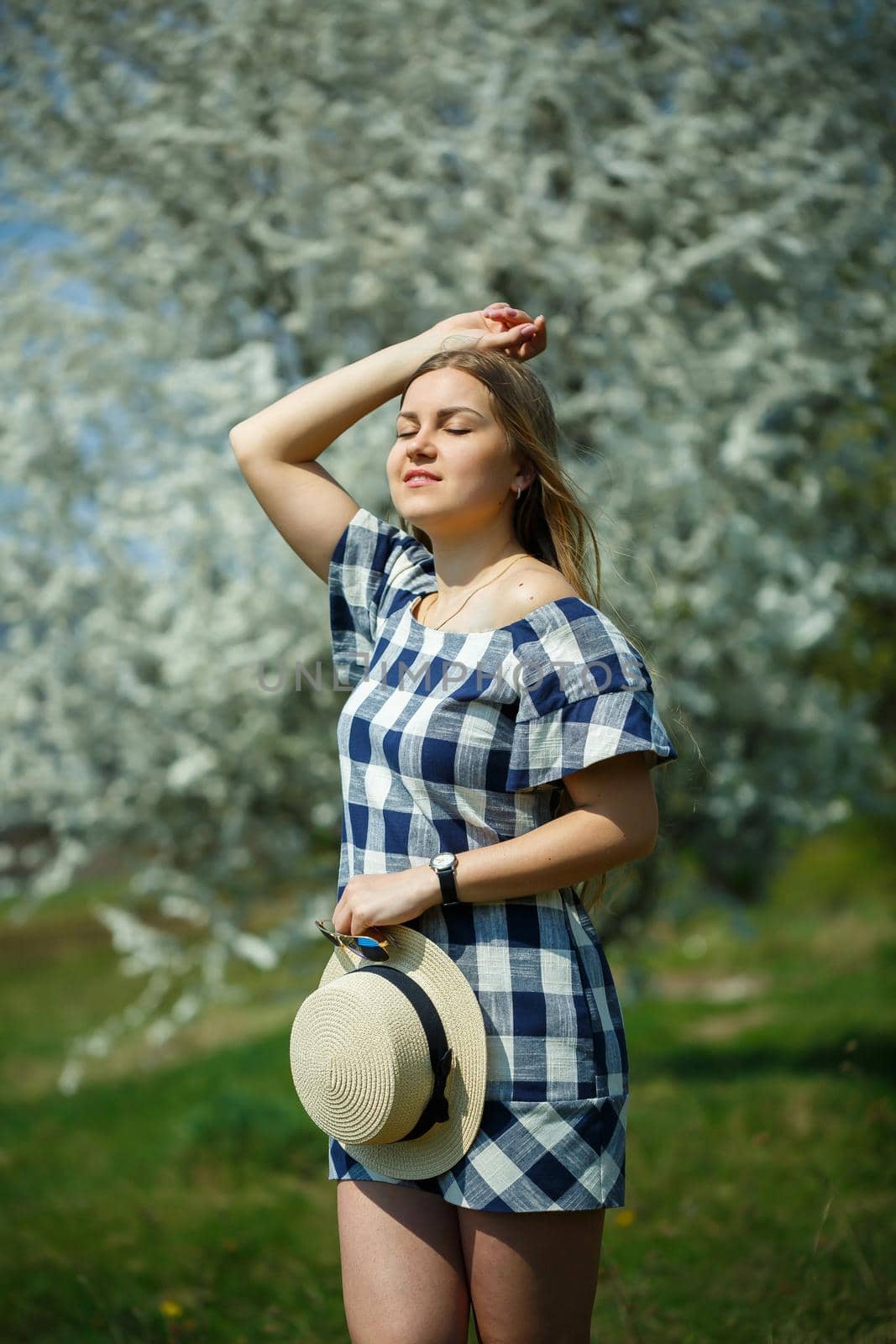 beautiful girl in a dress walking in the spring forest where the trees bloom