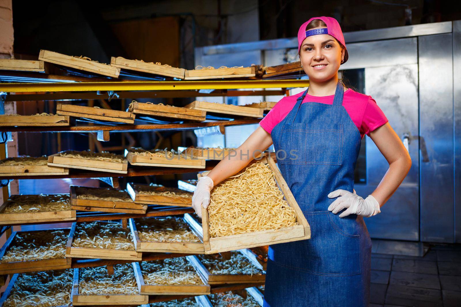 Make the noodles. Pasta factory. Spaghetti production. Raw pasta. Worker with a box of pasta. Girl works in the production of pasta