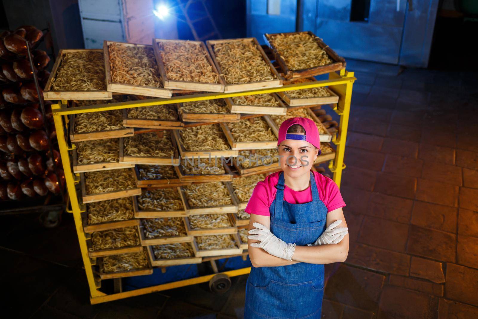 Worker with a box of pasta. The girl works on the production of spaghetti. Making noodles. Pasta factory.