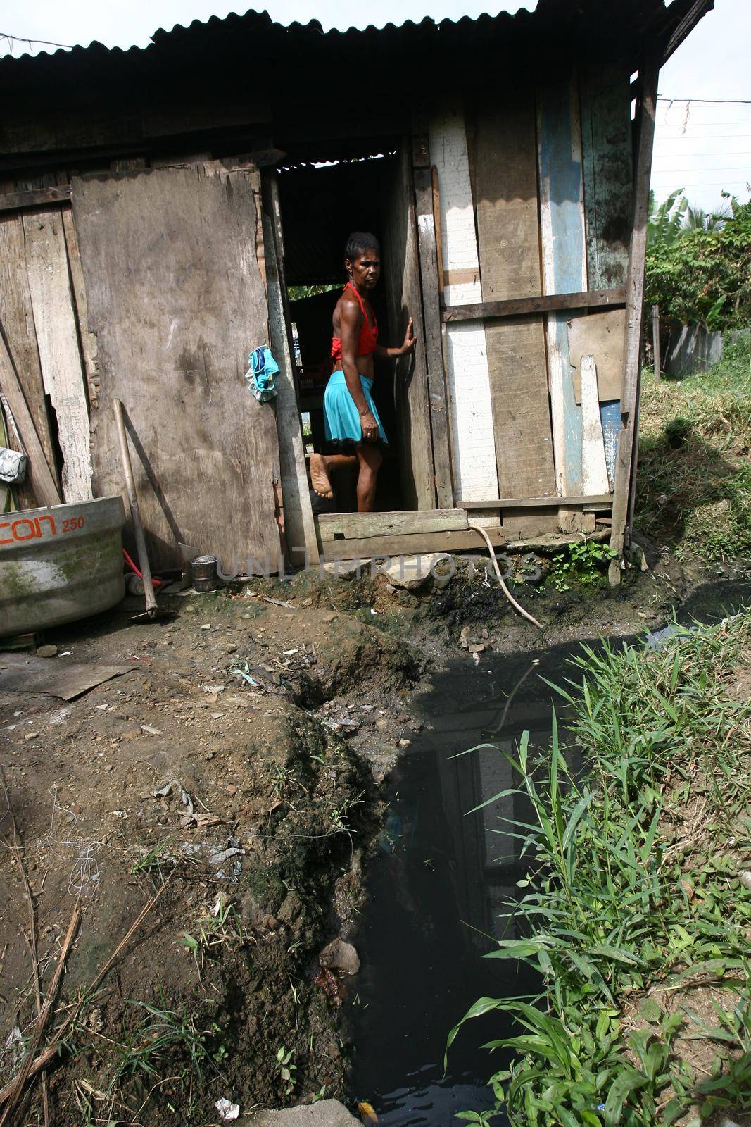 itabuna, bahia, brazil - january 5, 2012: open sewer next to a makeshift wooden house in a favela area in the city of Itabuna.