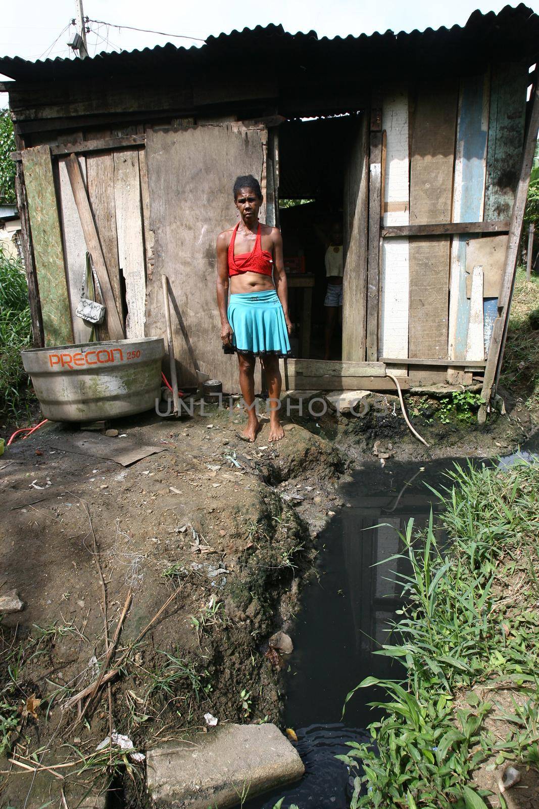 itabuna, bahia, brazil - january 5, 2012: open sewer next to a makeshift wooden house in a favela area in the city of Itabuna.